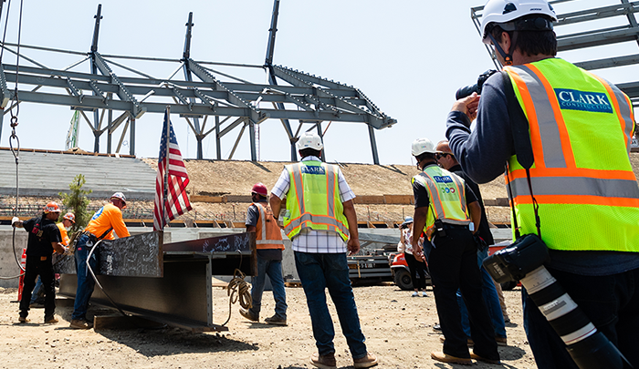 Construction workers hoisting a beam